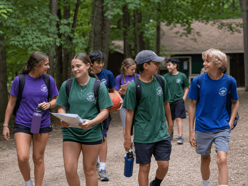 Campers wearing custom shirts while moving between summer camp activities