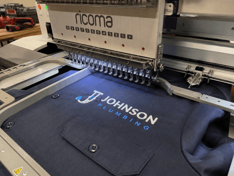 Custom plumbing company logo being applied to branded work shirts