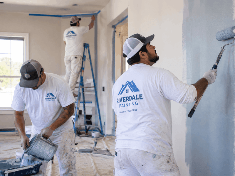 Professional painters wearing custom work shirts on the job