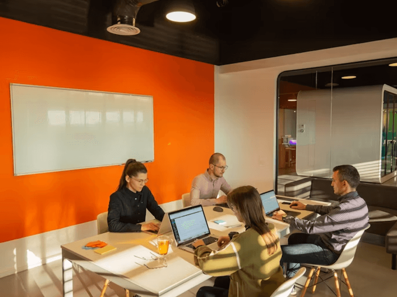 Startup team collaborating in a modern office while planning custom apparel and branded T-shirts for business growth.