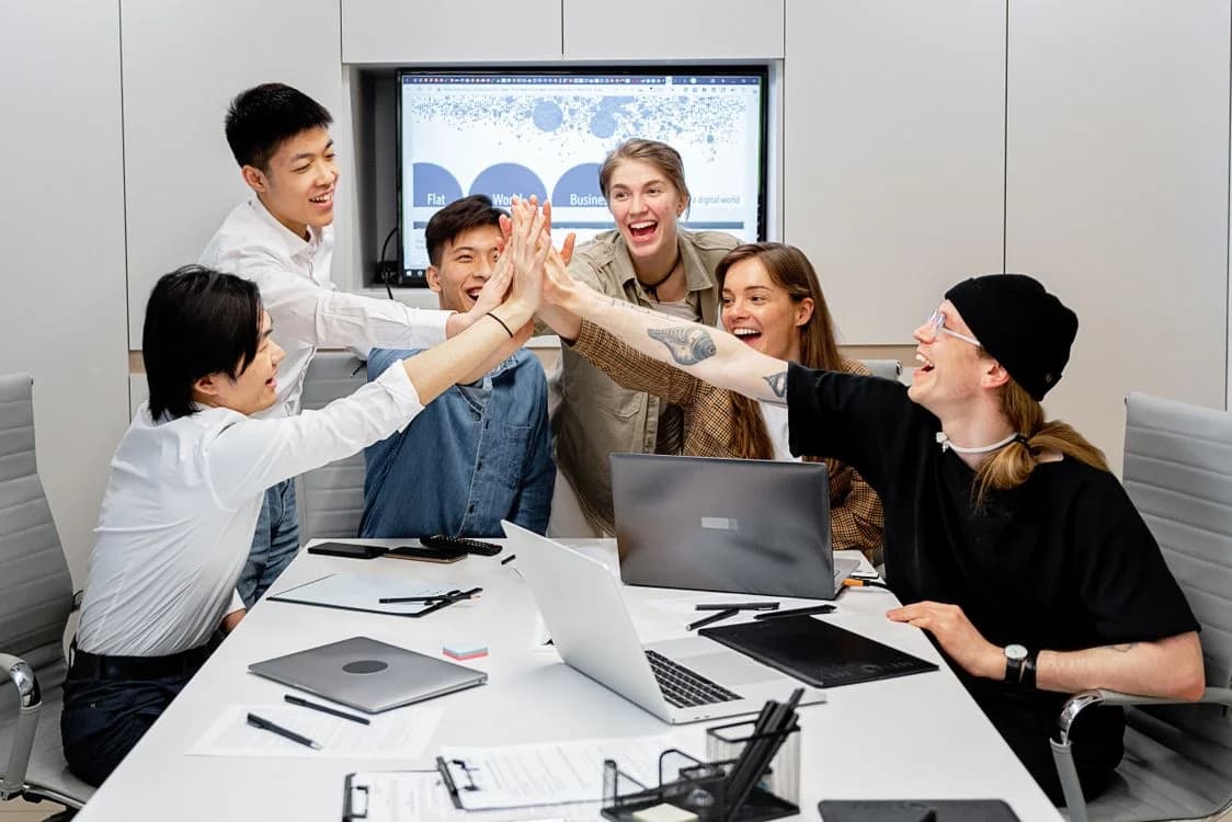 Startup team collaborating while wearing custom T-shirts and custom apparel for professional business branding.