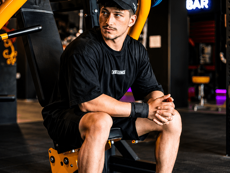 Fitness professionals wearing custom gym shirts inside a modern training facility.